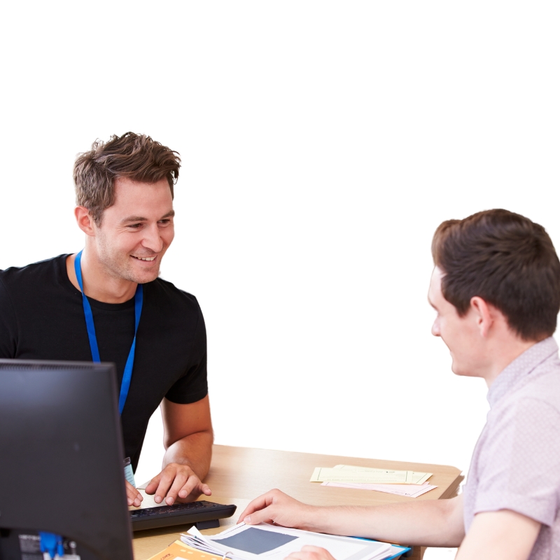 Two professionals engaged in a discussion at a desk equipped with a computer, showcasing effective teamwork in delivering Managed IT Services in Acacia Gardens